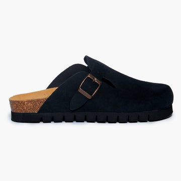 Black suede clog shoe with a buckle-up closure, adjustable strap, a flat cork insole and 15 mm heel height EVA outsole on a white background. Handmade in Spain